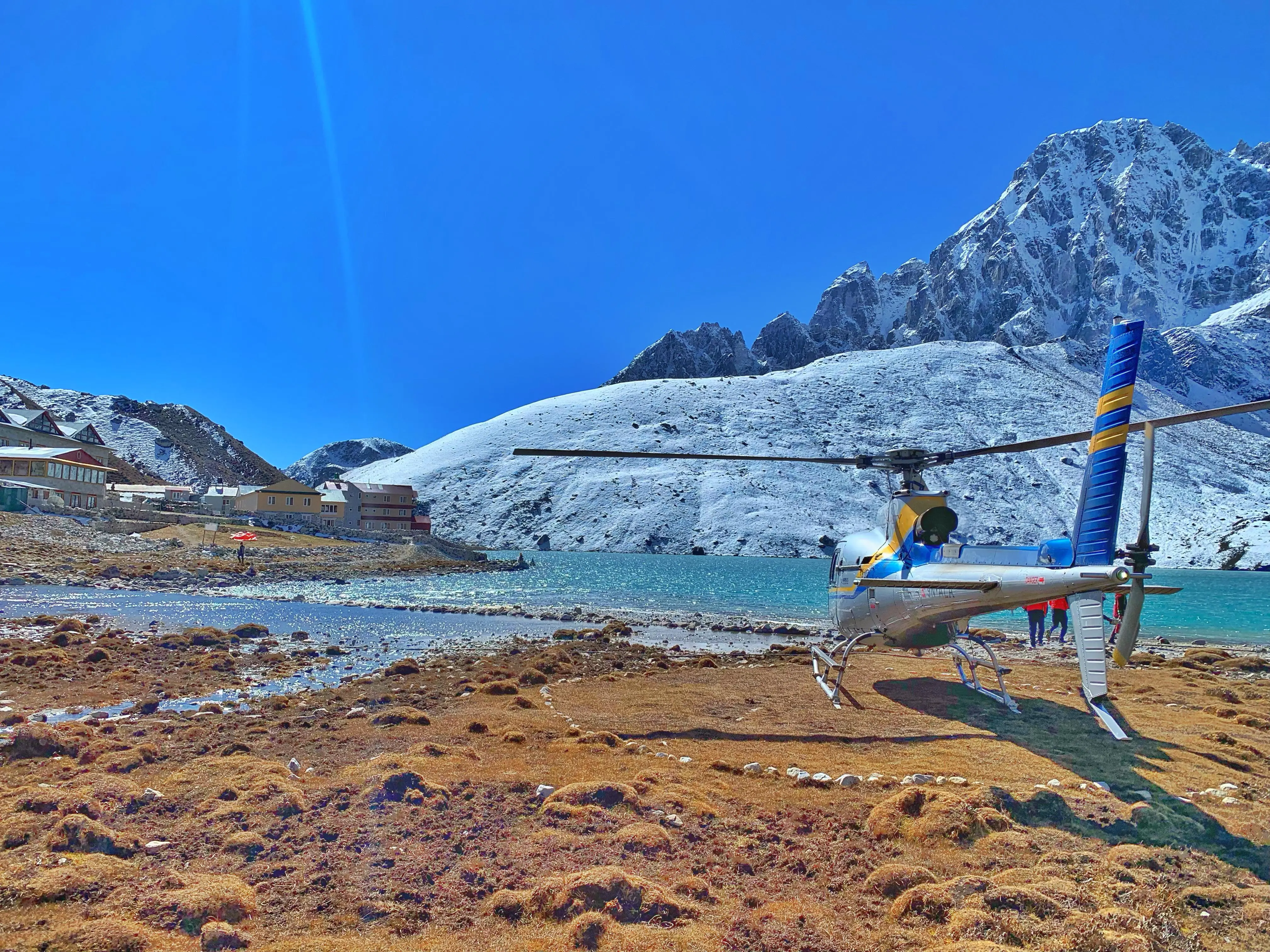 Aerial view from a helicopter leaving the Gokyo Valley (4,790m), showing turquoise lakes and mountain peaks en route to Kathmandu